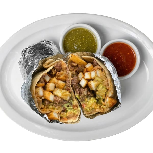 A Tacos El Primo burrito, cut in half, with two salsa cups on a white plate.