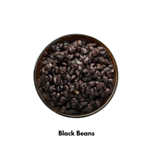 A bowl of Tacos El Primo's black beans, viewed from directly above on a white background.